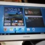 A Samsung Galaxy Tab, specifically the Galaxy Note 10.1 variant, is shown on a person's lap.